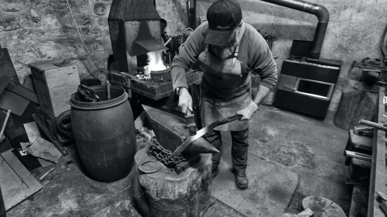 un homme forge un couteau de manière artisanale